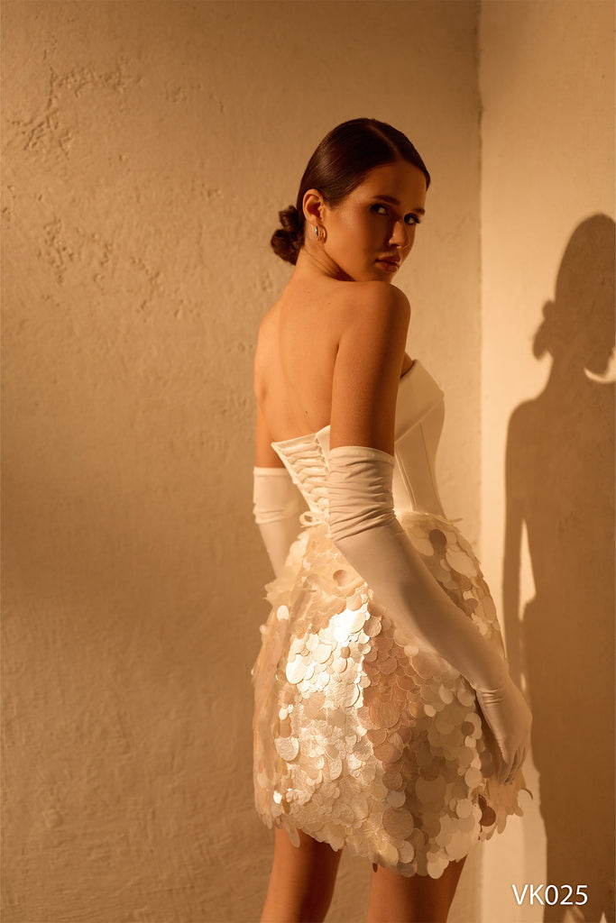 Strapless bridal mini dress with structured corset bodice, oversized sequin embellishments, lace-up back, and opera gloves