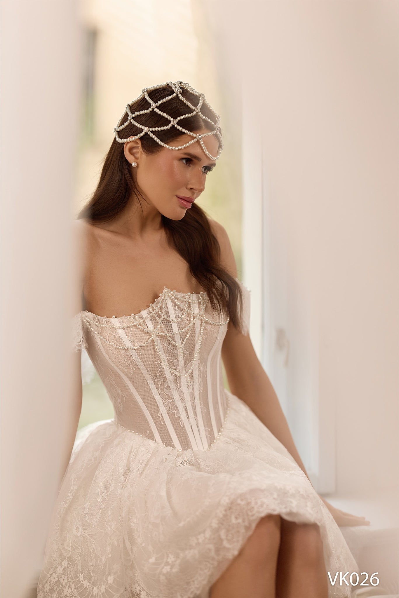 Off-the-shoulder bridal mini dress with sheer corset bodice, pearl draping, lace detailing, voluminous skirt, and lace-up back