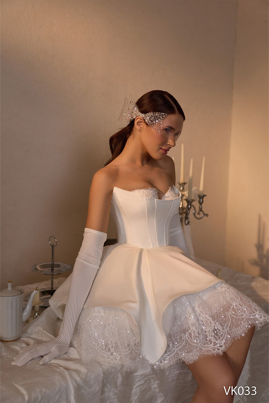 Strapless bridal mini dress with structured overskirt, corset bodice, and sparkling lace detailing