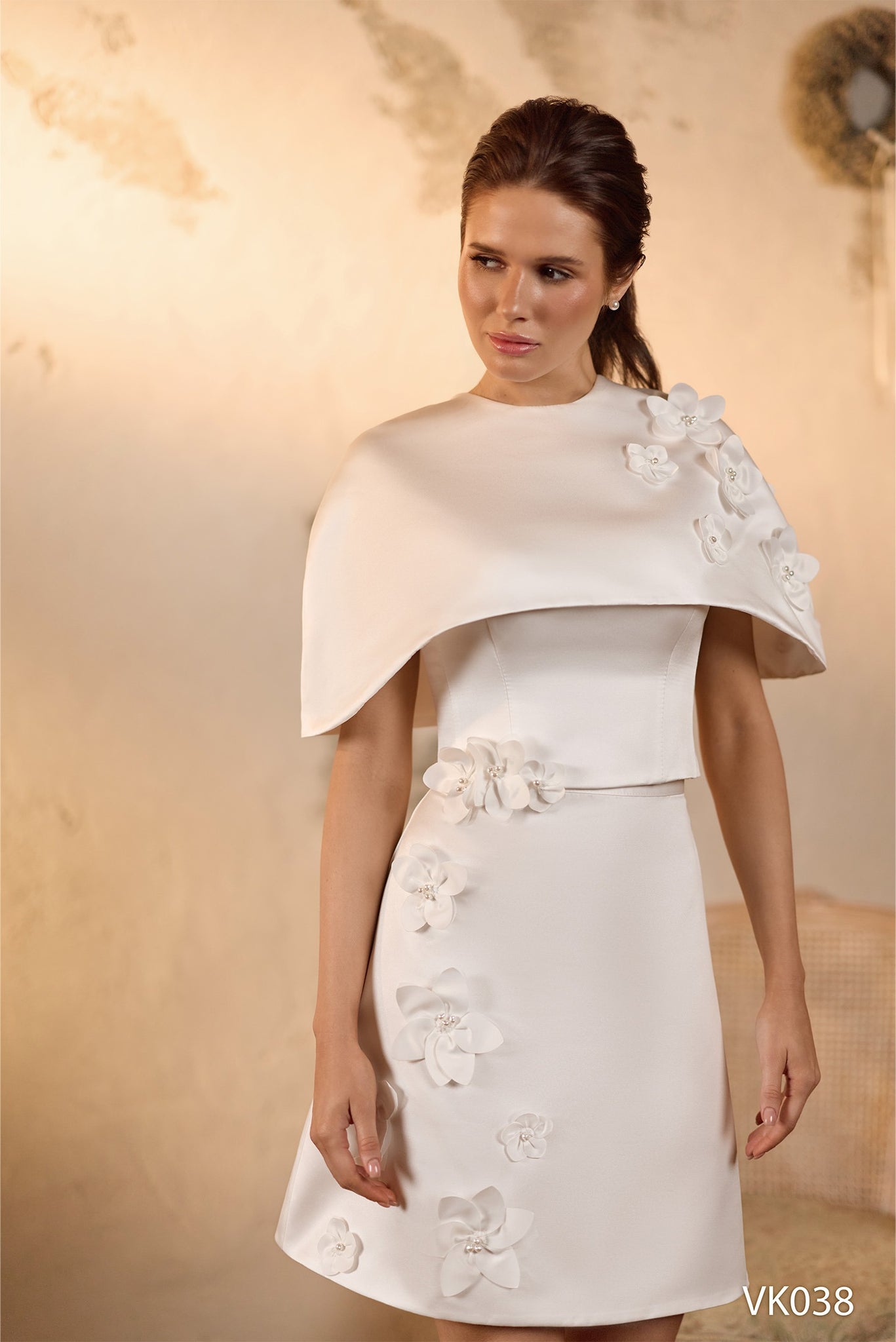 Modern strapless bridal dress with floral appliqués, flowing midi and mini skirt options, and detachable cape