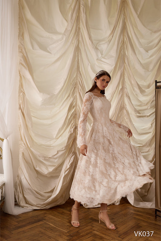 Lace bridal gown with structured corset bodice, sheer long sleeves, and flowing A-line skirt
