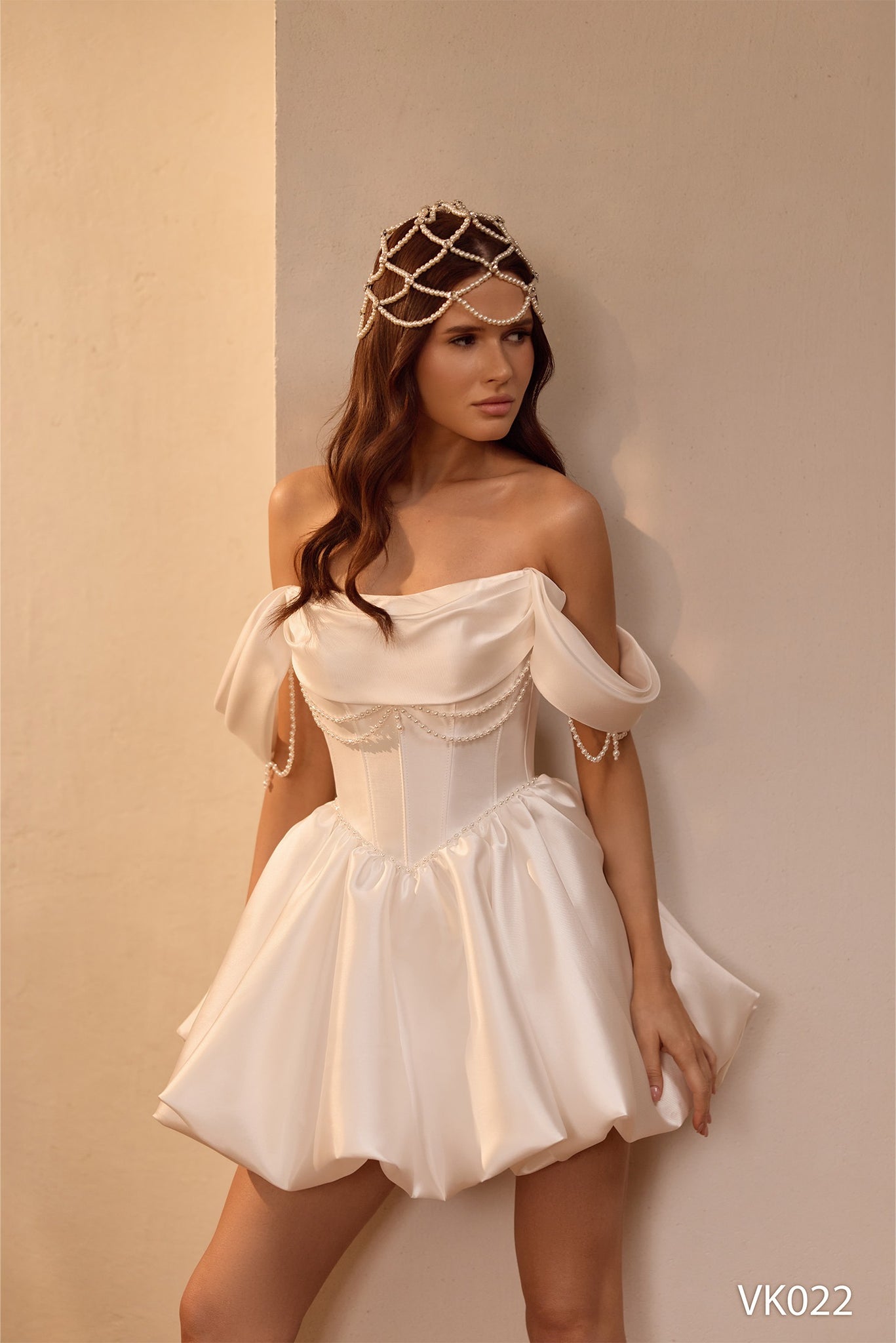 Off-the-shoulder bridal mini dress with structured corset bodice, pearl draping, lace sleeves, voluminous bubble skirt, and lace-up back