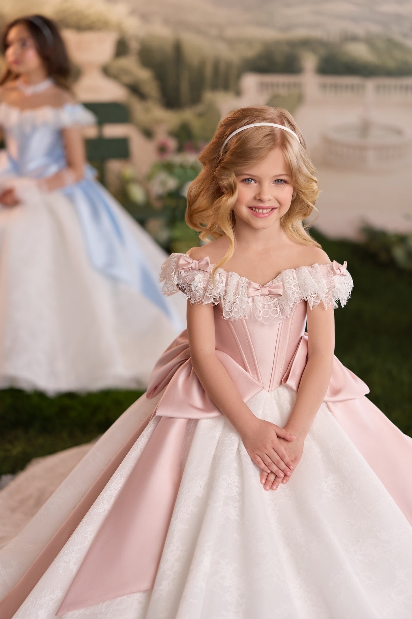 Girl wearing a pink and white off the shoulder ball gown with lace trim
