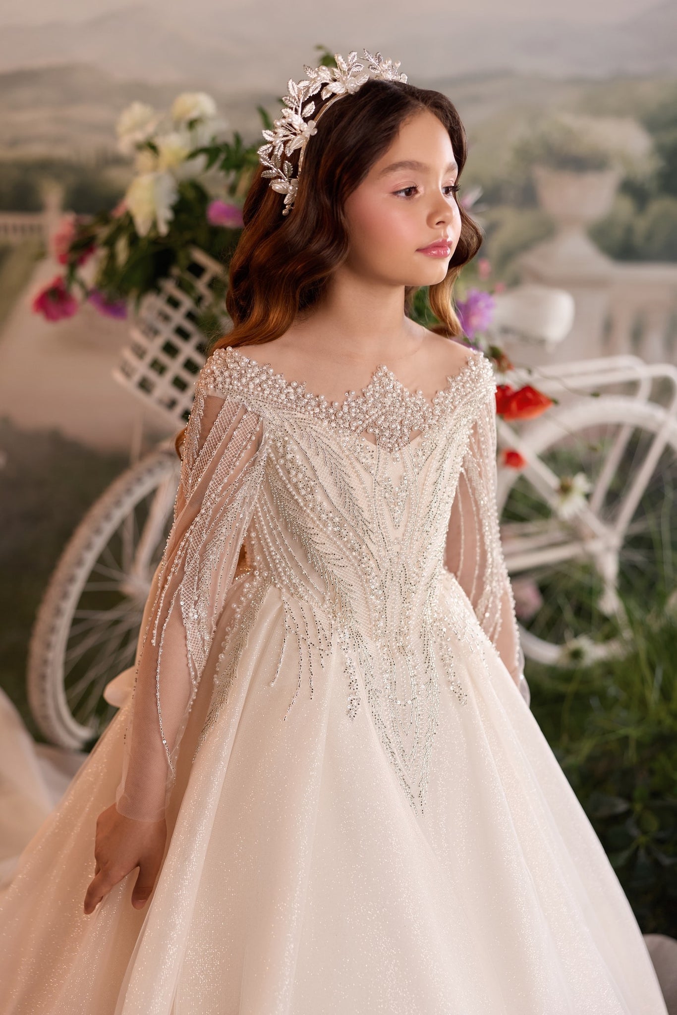 Girl wearing a beaded off-shoulder gown and a silver leaf tiara