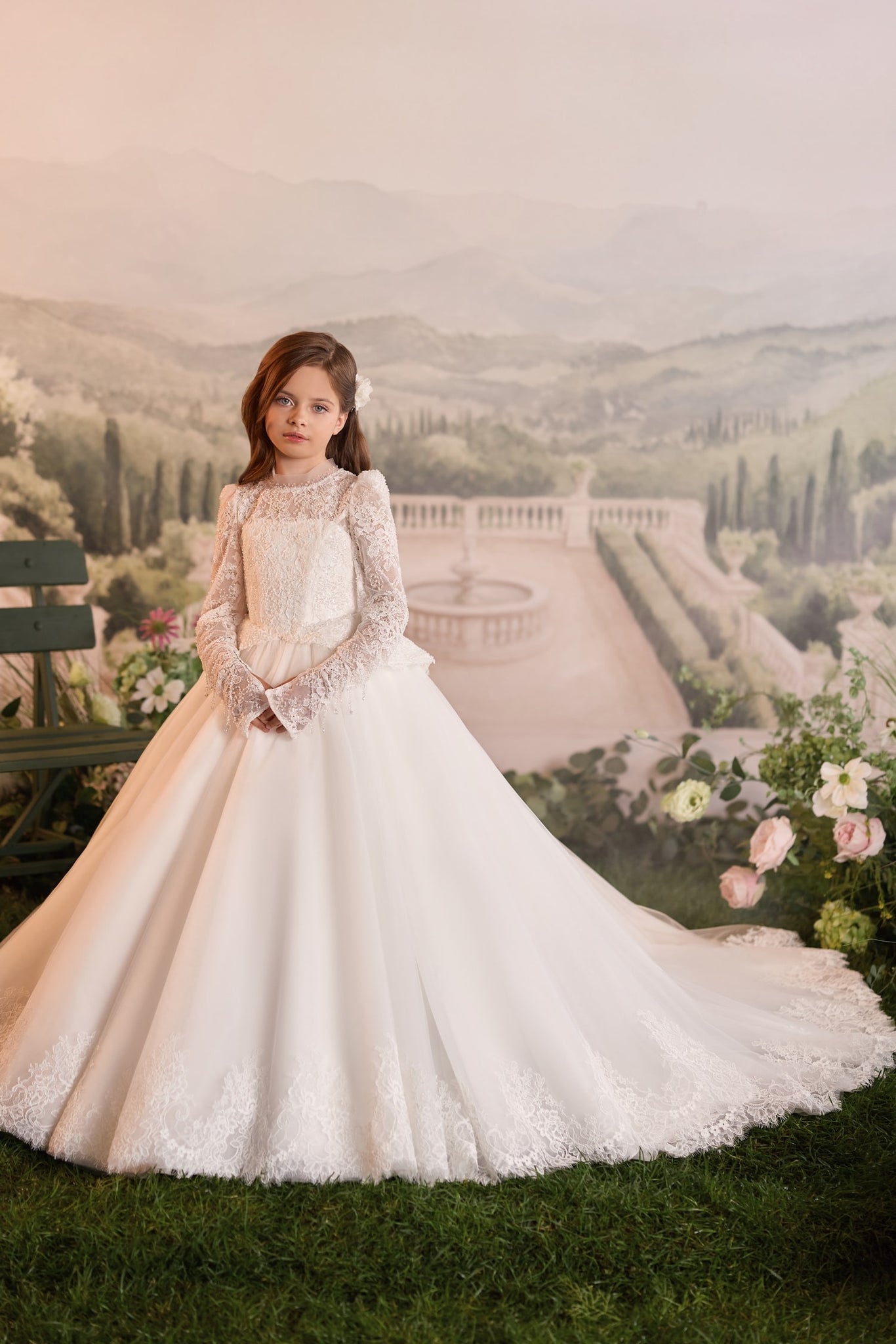 Girl wearing a white long sleeve lace communion dress with a full skirt