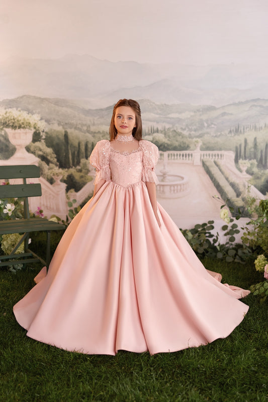 Girl wearing a pink ball gown with puff sleeves and lace detail