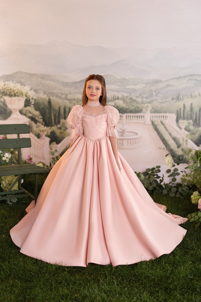Girl wearing a pink ball gown with puff sleeves and lace detail | Girls Formal Dress