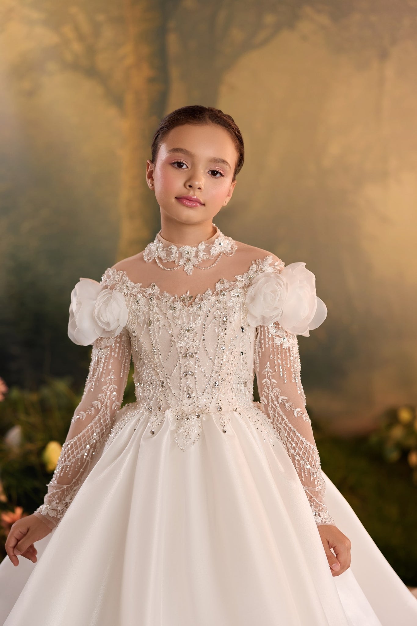 Girl wearing a white formal dress with lace embroidery and floral shoulder details