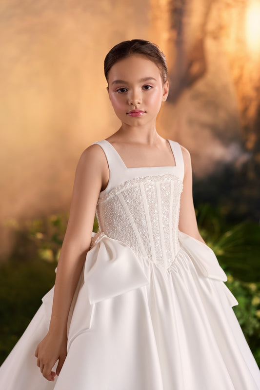 Girl wearing a white sleeveless dress with a sequined corset bodice and full skirt