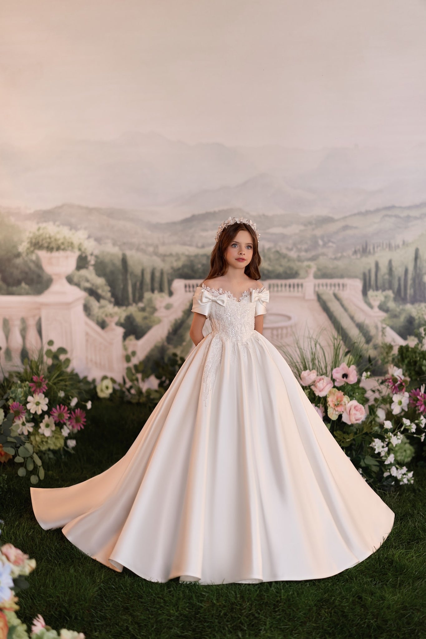 Girl wearing a white off-shoulder ball gown with lace bodice and floral crown