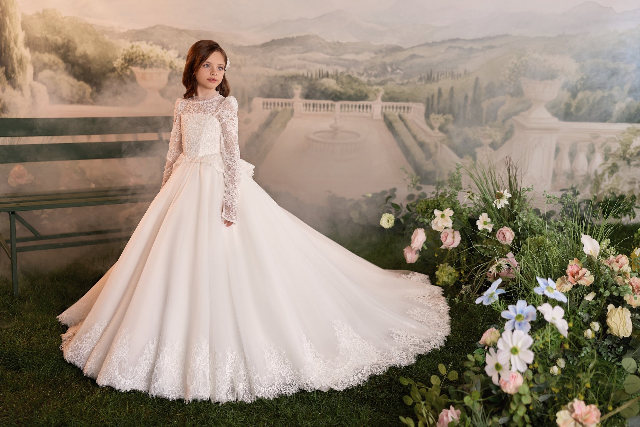 Girl wearing a long white lace communion dress with a full skirt