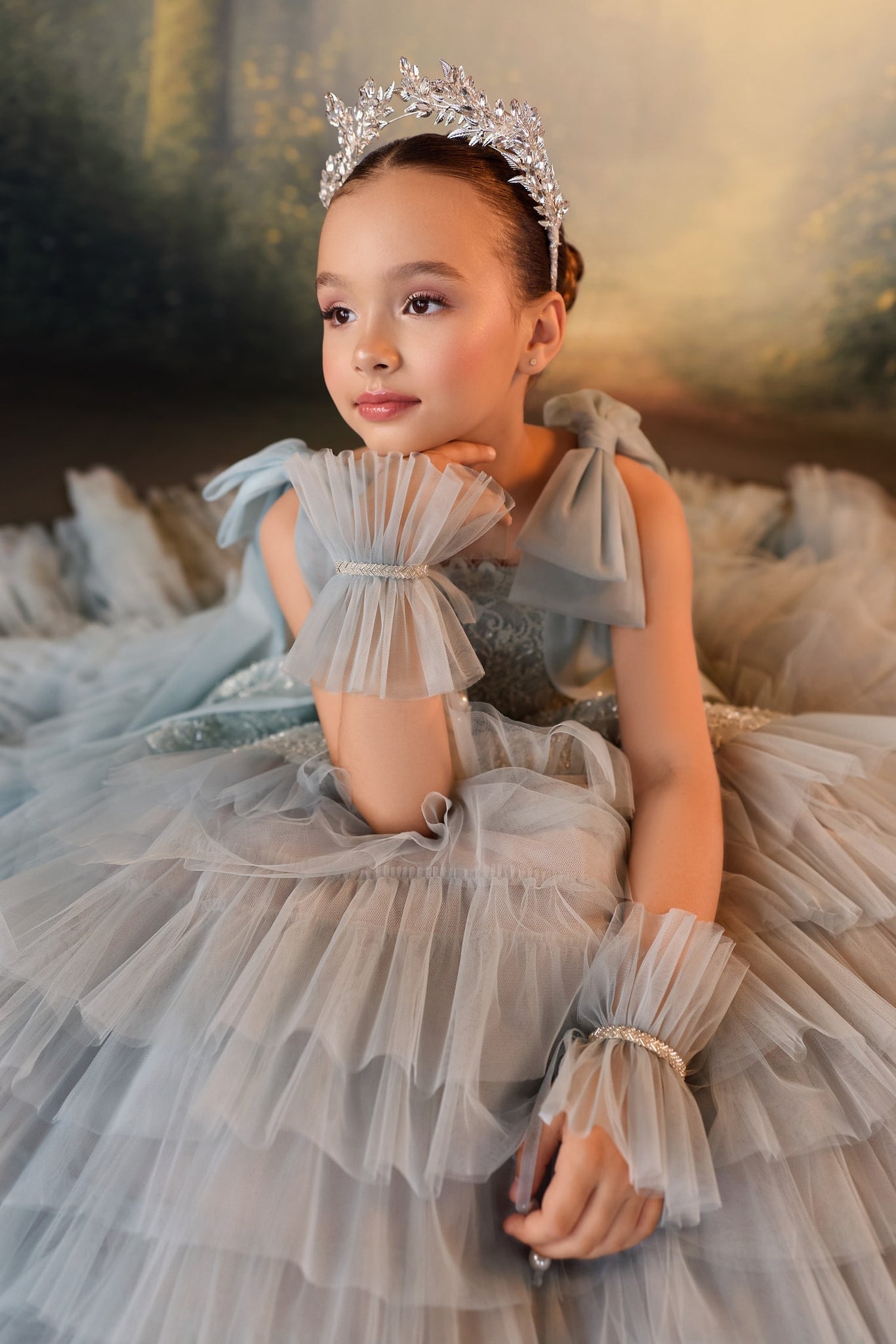 Girl wearing a grey tulle dress with ruffled cuffs and a crystal tiara
