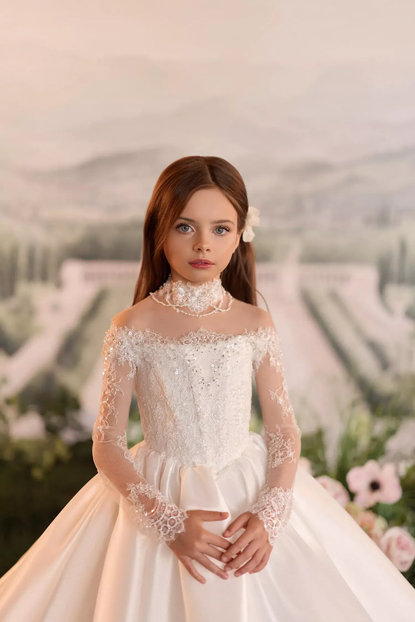 Girl wearing a white lace off the shoulder dress with long sleeves and a pearl choker