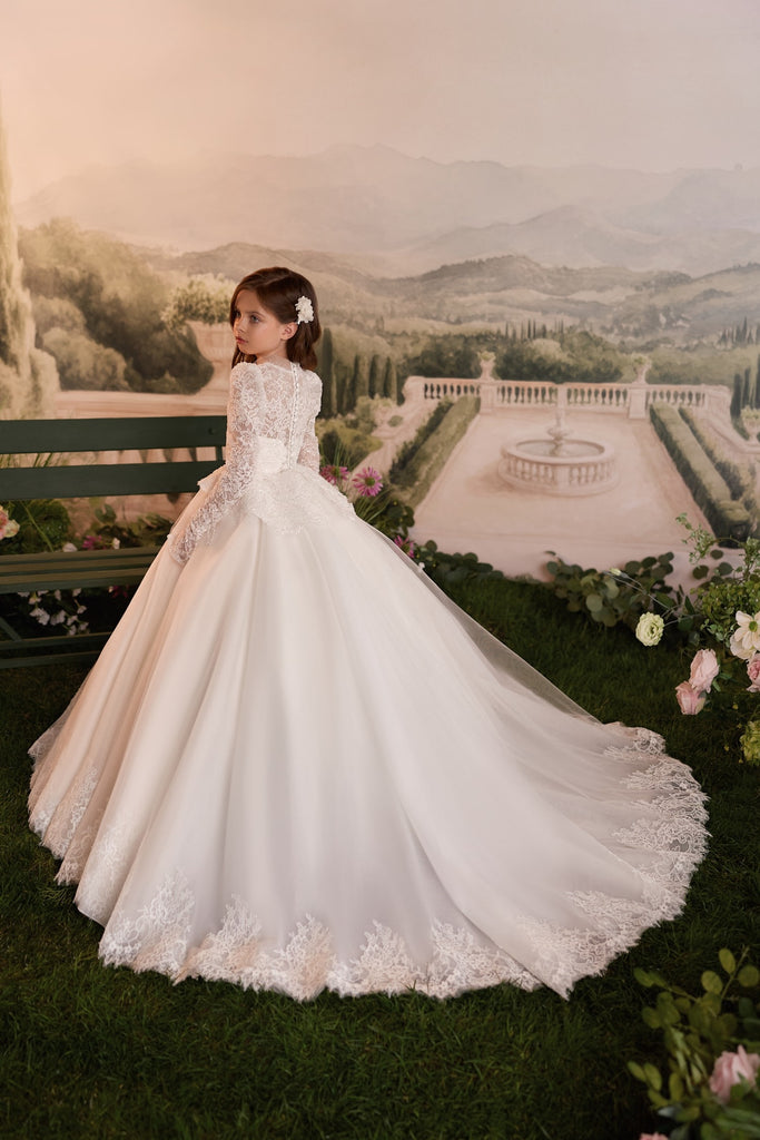 Girl wearing a white lace long sleeve ball gown with a full skirt and train | Girls Formal Dress