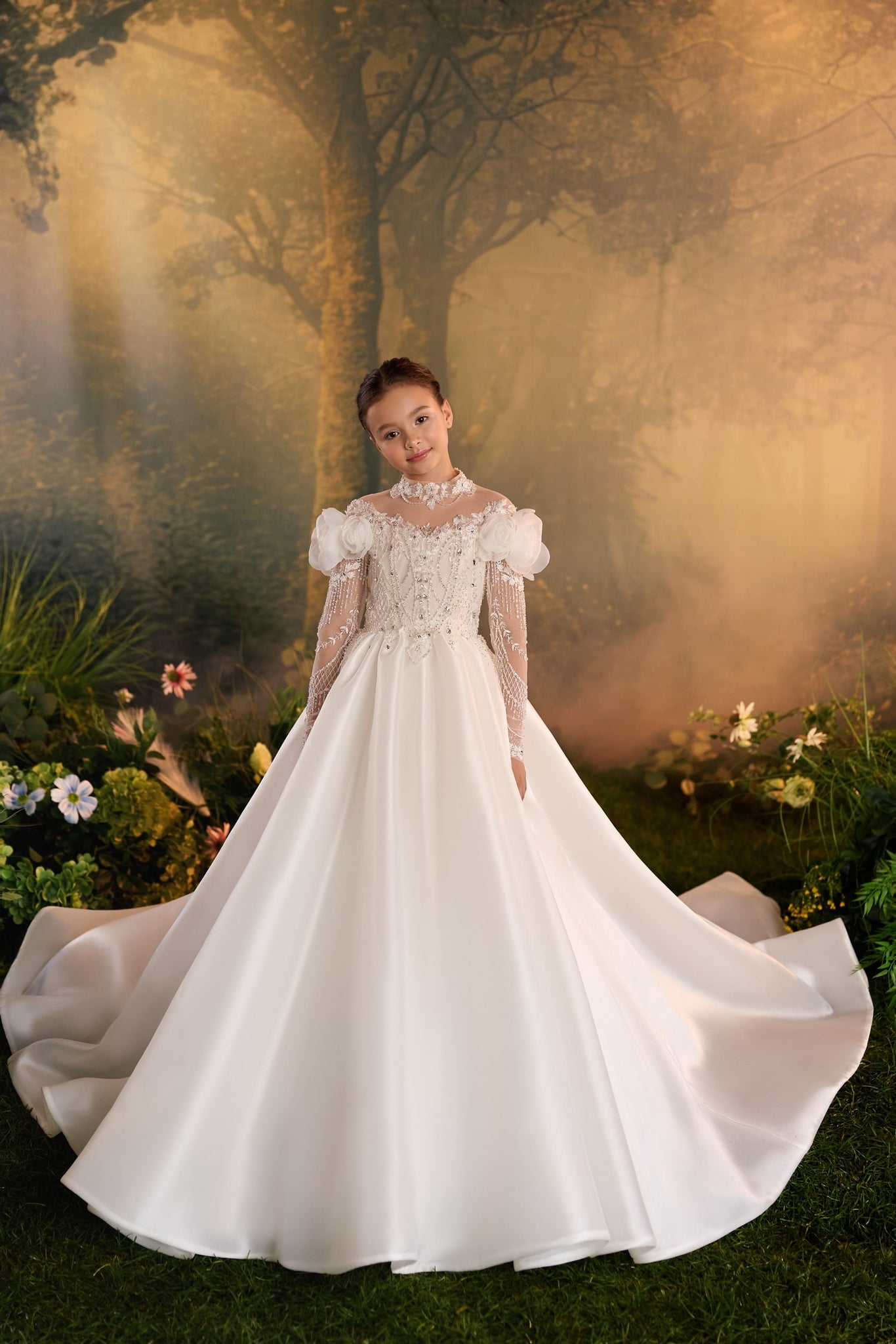 Girl wearing a white long sleeve ball gown with floral embellishments and a full skirt in a forest setting