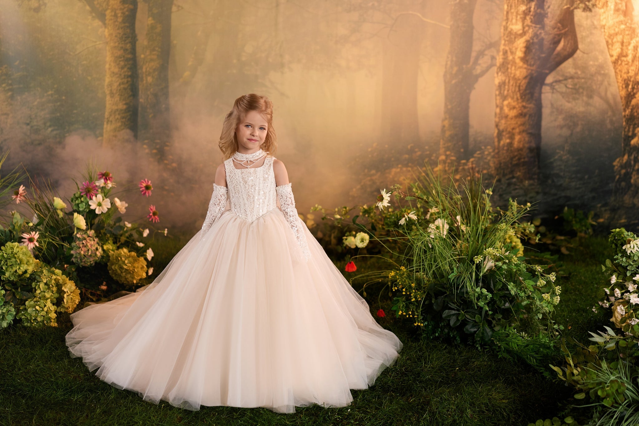 Girl wearing a formal ball gown with a softly squared neckline, lace sleeves, and a full skirt in a forest setting | Girls Formal Dress