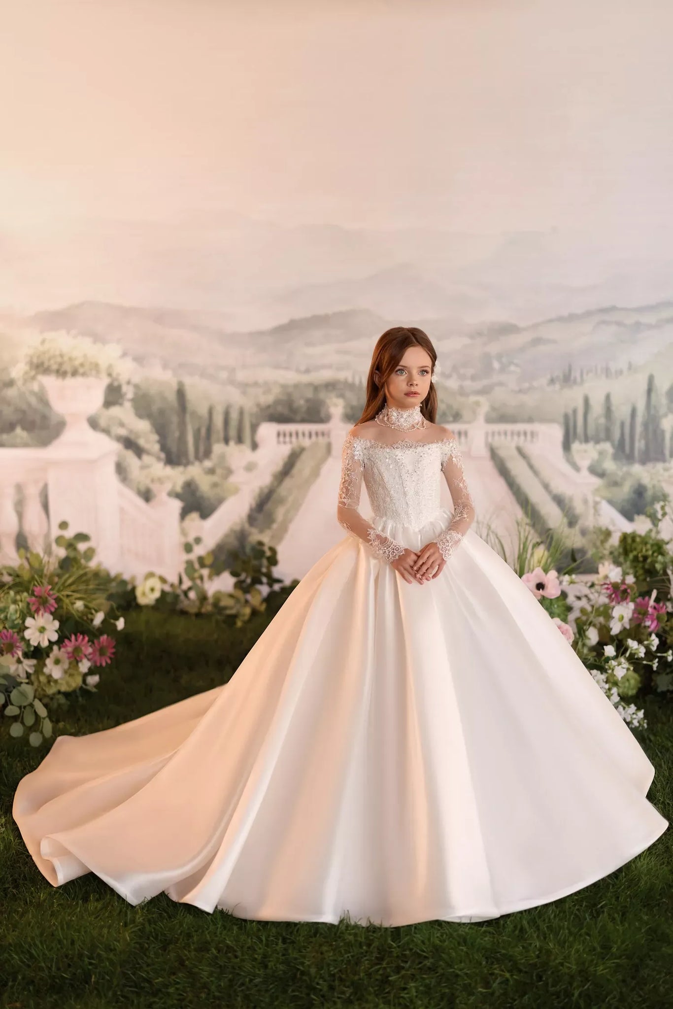Girl wearing a white off the shoulder ball gown with lace sleeves and a high neck