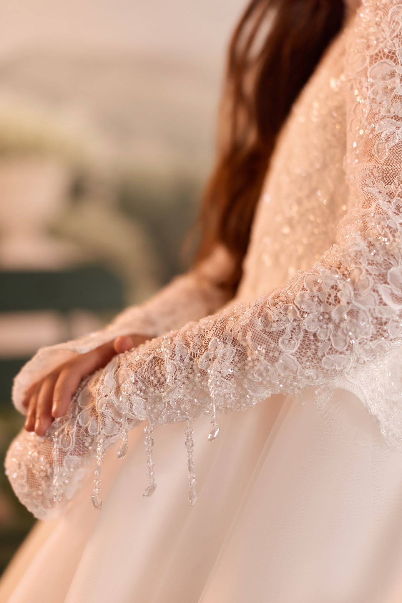 Close up of white lace long sleeve dress with beaded fringe detail