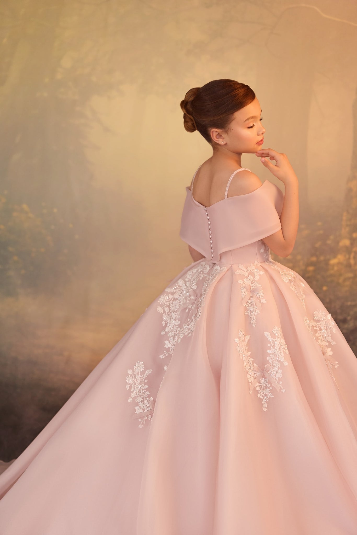 Girl wearing a pink off the shoulder ball gown with white lace floral embroidery and button back detail