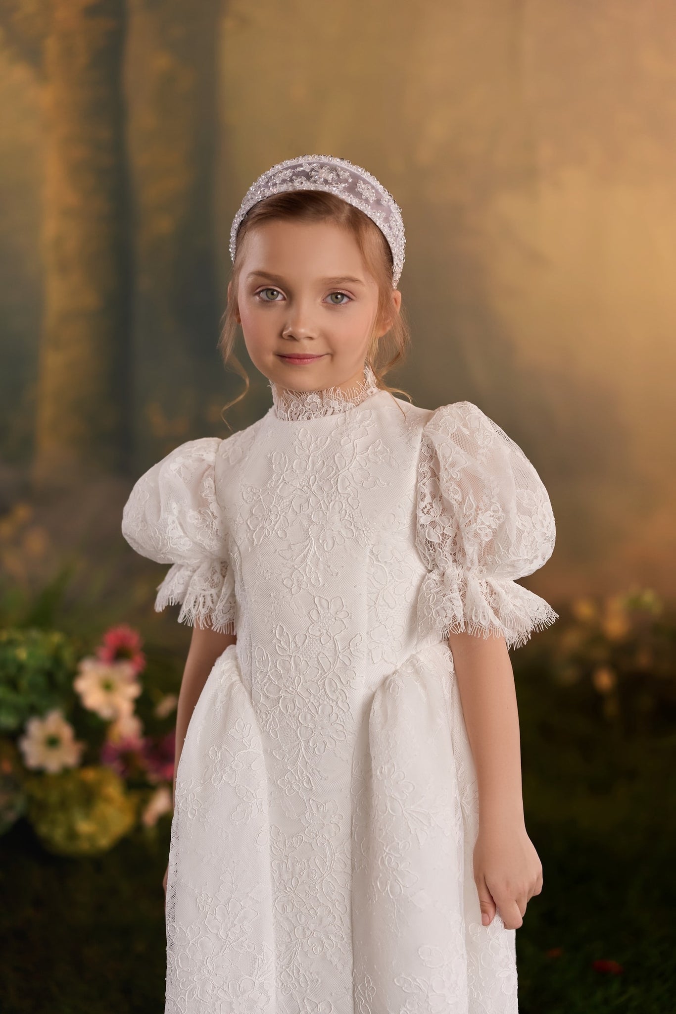 Girl wearing a lace dress with puff sleeves, a lace headband, and a matching lace collar against a forest backdrop | Girls Formal Dress