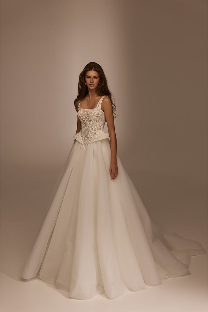 Model wearing a white A-line wedding dress with a square neckline and lace corset bodice