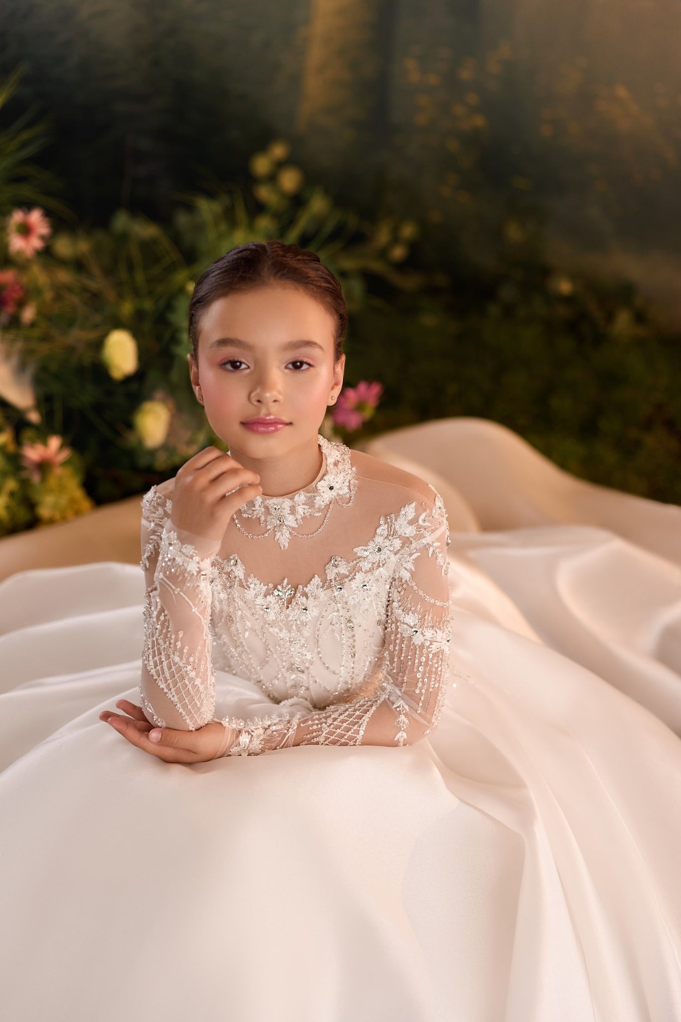 Girl wearing a white long sleeve ball gown with beaded lace bodice and sheer neckline