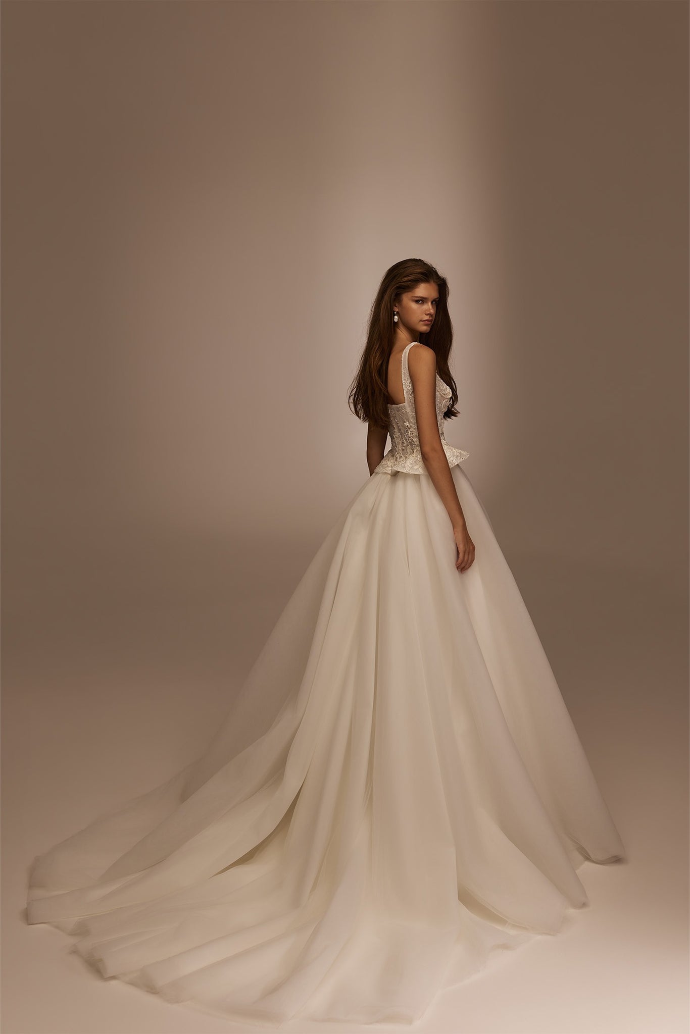Woman wearing a white sleeveless wedding dress with a lace bodice and full tulle skirt