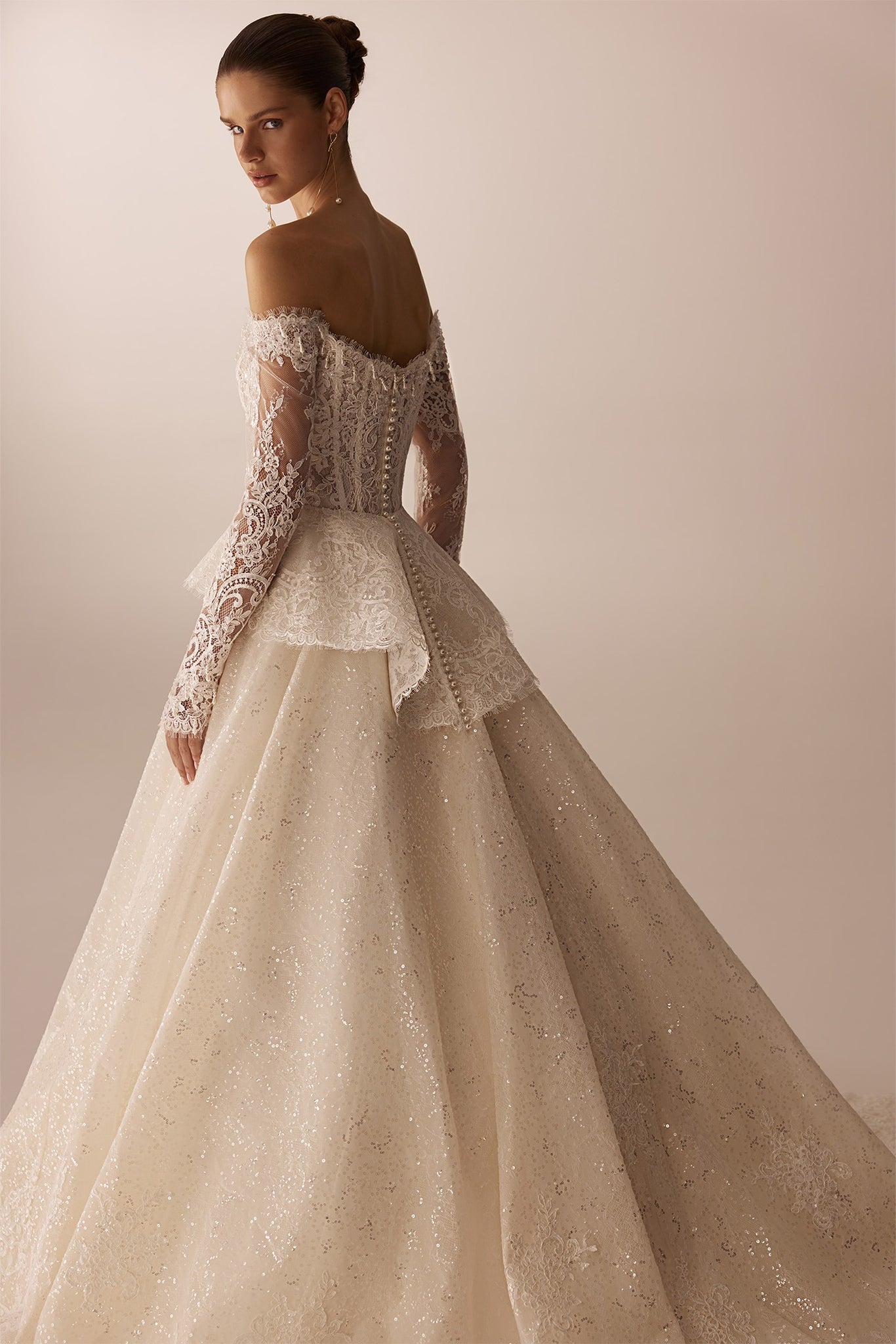 Off the shoulder lace wedding dress with long sleeves and a full sequined skirt