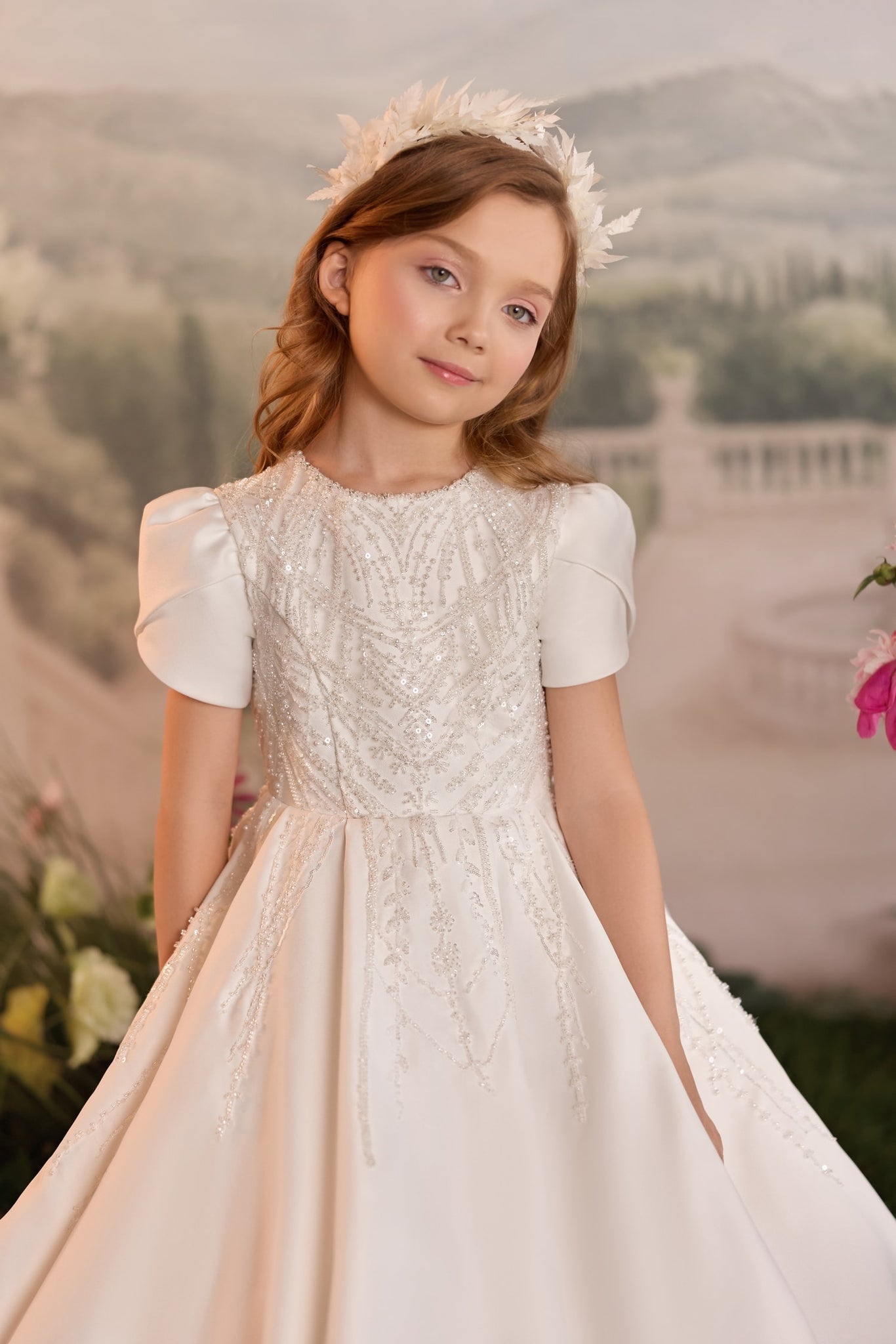 Girl wearing a white beaded dress and a floral headpiece