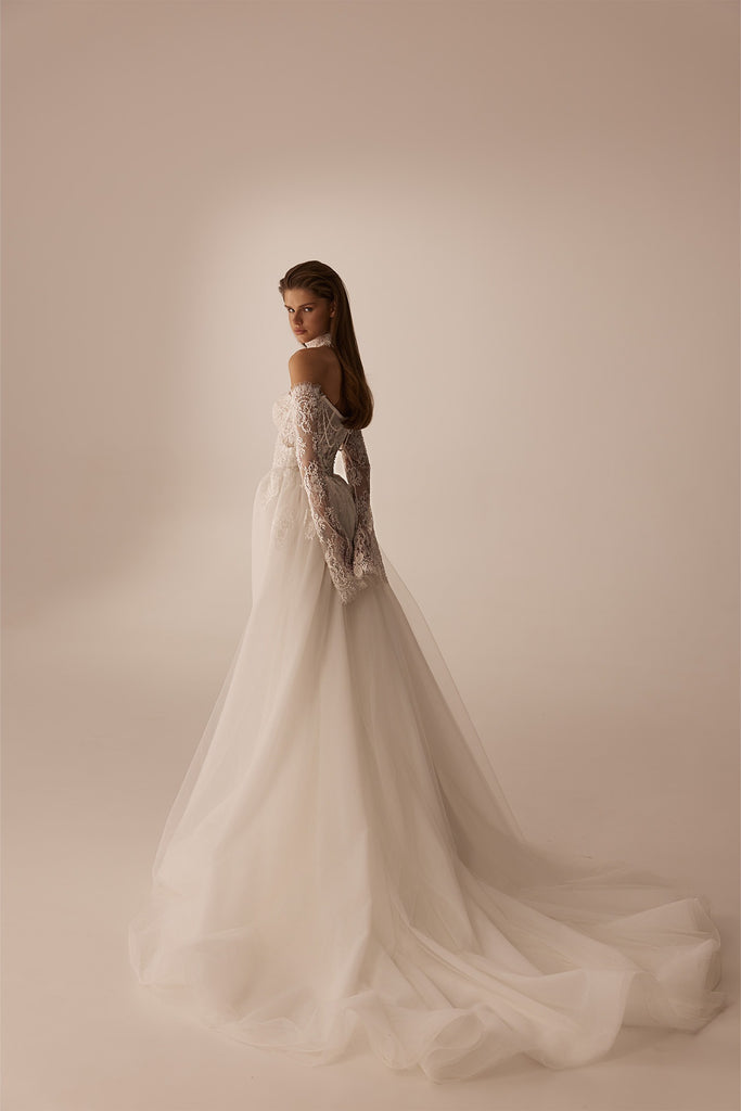 Model wearing an off the shoulder long sleeve lace wedding dress with a full tulle skirt
