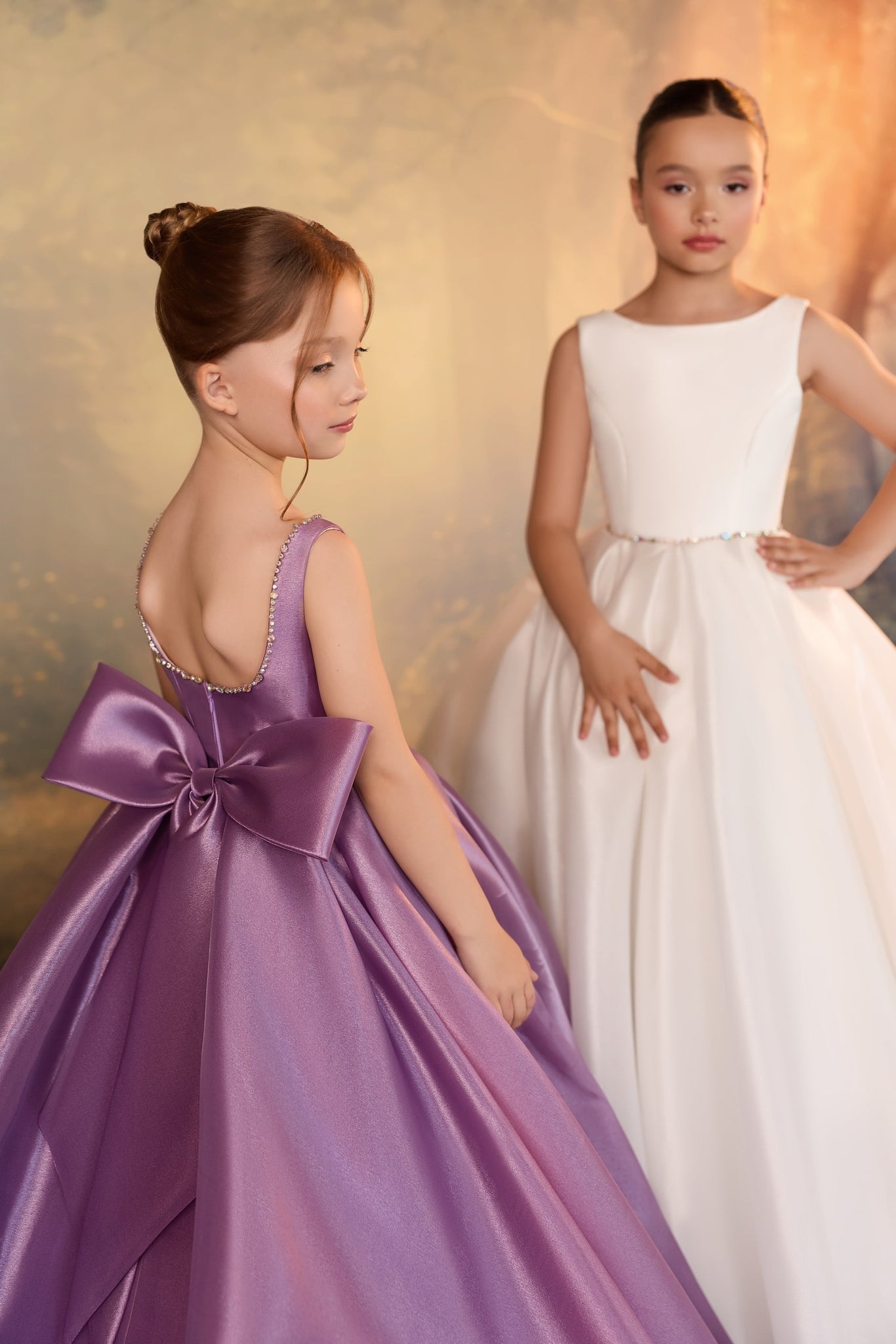 Two girls wearing formal ivory and lilac dresses with jeweled details | Girls Formal Dress