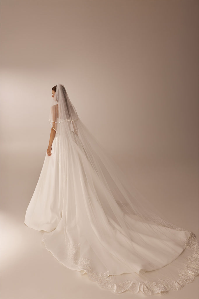 Bride wearing a long white wedding dress with a floor length veil