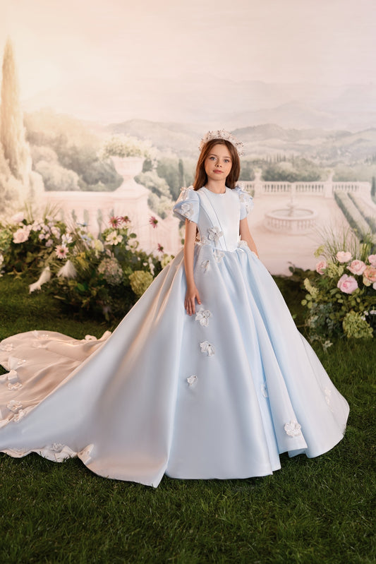 Girl wearing a light blue ball gown with floral embellishments and a matching crown