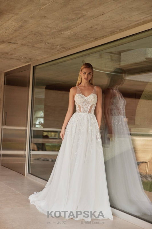 Airy A-line wedding dress with a semi-sheer lace corset bodice, delicate straps, soft tulle skirt, and subtle shimmer detailing