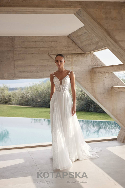 Airy A-line wedding dress with a lace corset bodice, delicate straps, flowing chiffon skirt, lace inserts, and detachable long sleeve lace topper