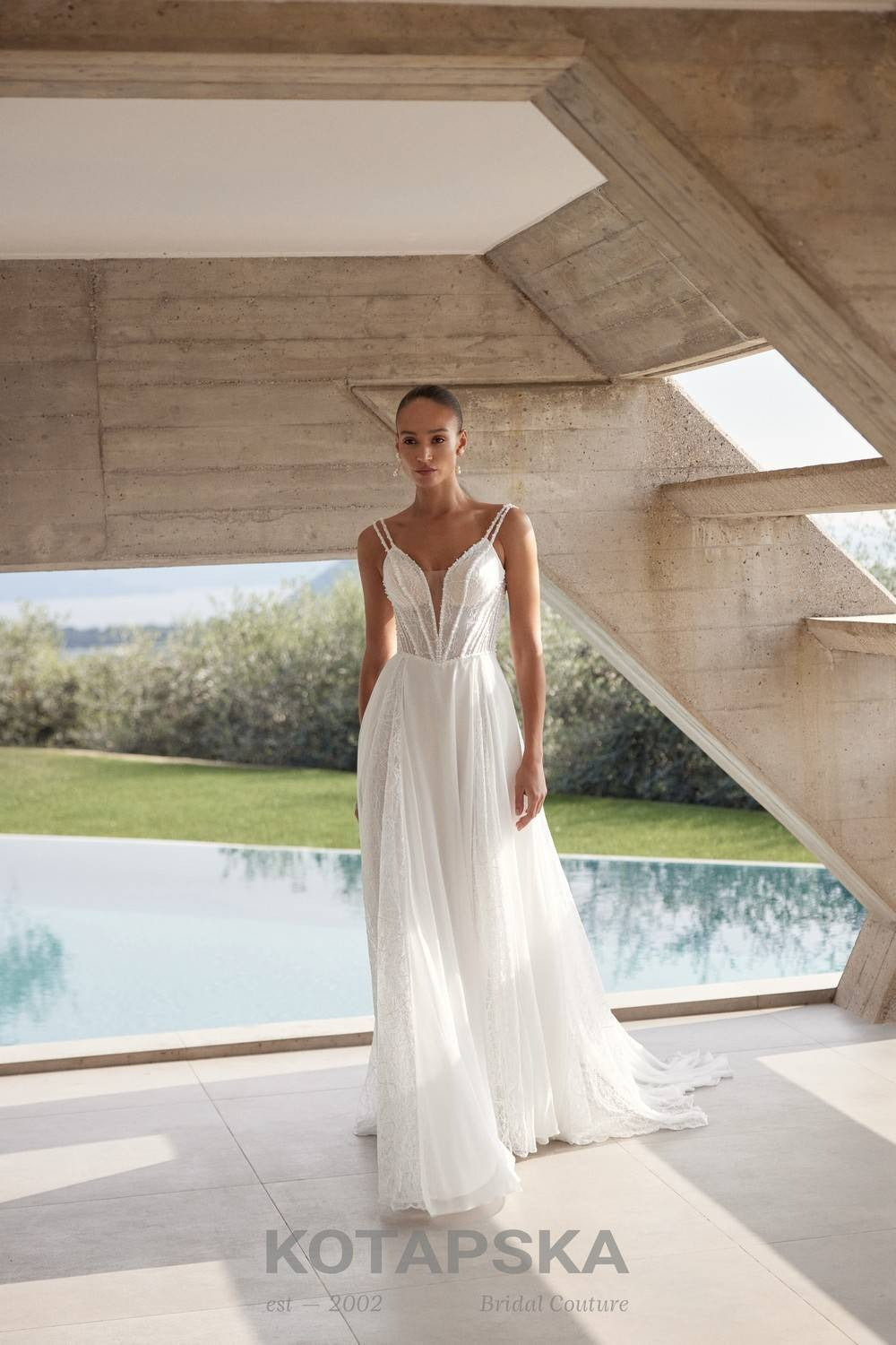 Airy A-line wedding dress with a lace corset bodice, delicate straps, flowing chiffon skirt, lace inserts, and detachable long sleeve lace topper