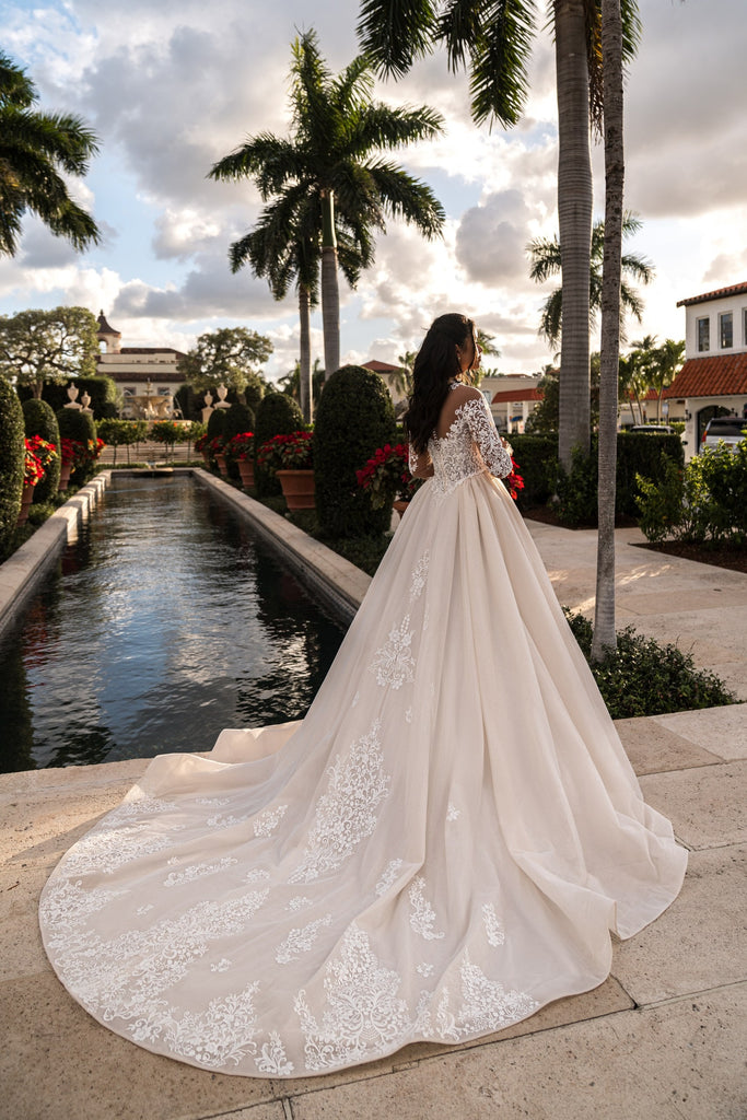 EMABRIDE 265 wedding dress with high illusion neckline, long sleeves, lace bodice, and detailed train on an A-line silhouette