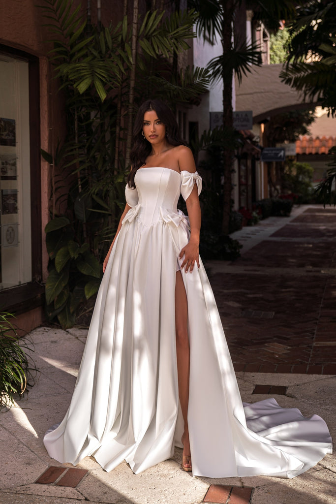 EMABRIDE 273 wedding dress with off-the-shoulder bodice, sleeve bows, waist bow details, high slit, and full skirt