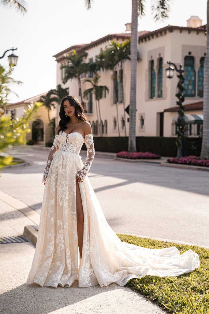 EMABRIDE 274 wedding dress with off-the-shoulder neckline, long sleeves, floral embroidery, slit, and flowing A-line skirt