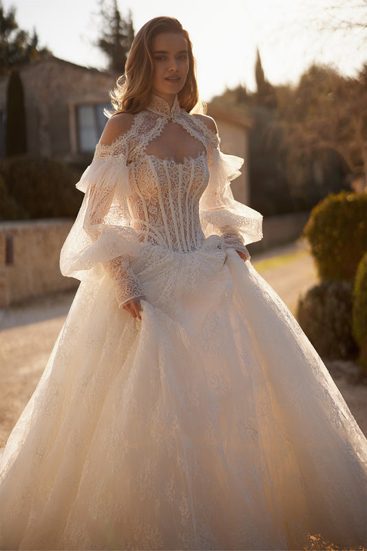 Woman wearing a white lace wedding dress with long puff sleeves and a corset bodice