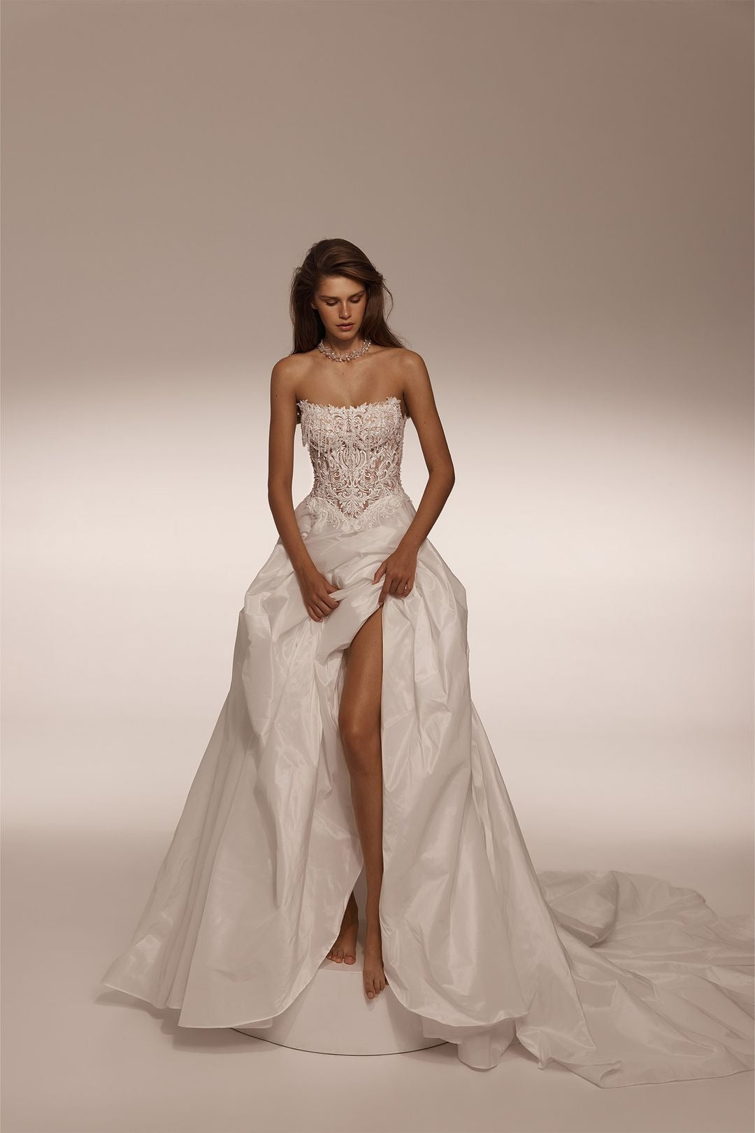 Strapless wedding dress with lace corset bodice and full skirt with high leg slit