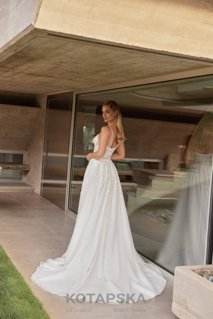 Airy A-line wedding dress with a semi-sheer lace corset bodice, delicate straps, soft tulle skirt, and subtle shimmer detailing