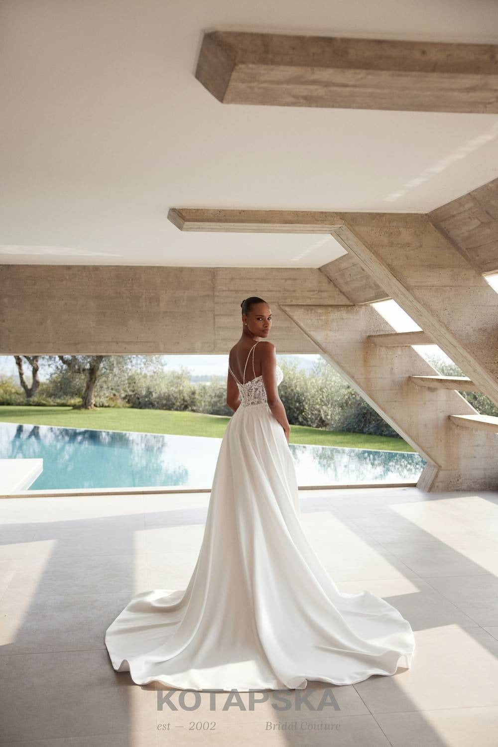 Satin A-line wedding dress with a lace corset bodice, sheer waist inserts, delicate straps, high slit, and a flowing train