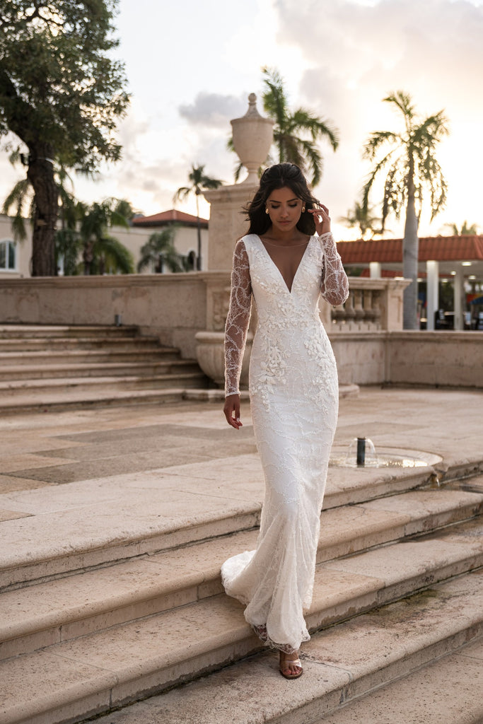 EMABRIDE 268 fitted wedding dress with deep V neckline, illusion inset, long embroidered sleeves, and floral appliqué detail