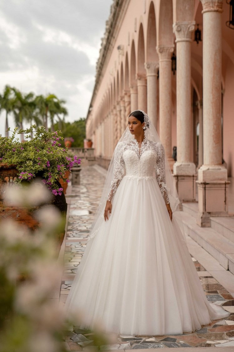 Princess-style wedding gown with lace bodice, long sleeves, and full embellished skirt