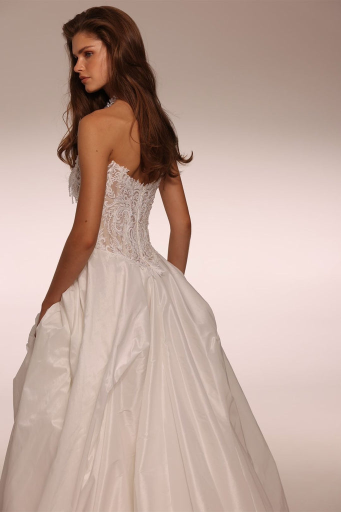 Model wearing a strapless white ballgown with a lace bodice and full skirt