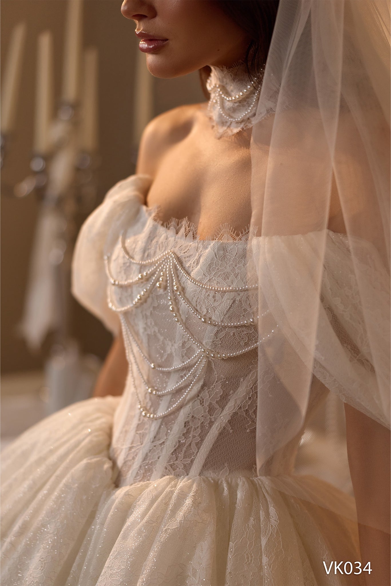 Short bridal dress with pearl-draped corset bodice, off-the-shoulder sleeves, lace detailing, and bubble skirt