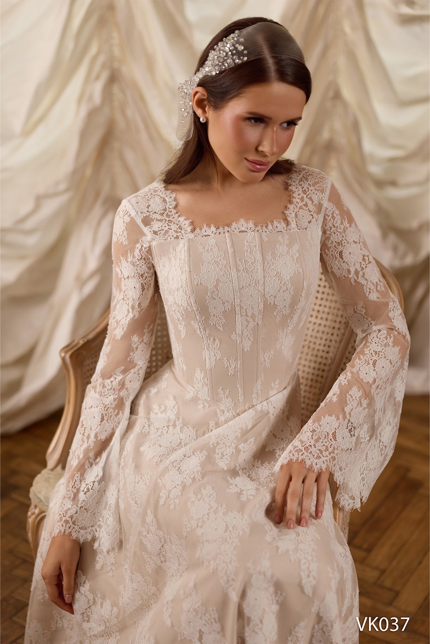 Lace bridal gown with structured corset bodice, sheer long sleeves, and flowing A-line skirt