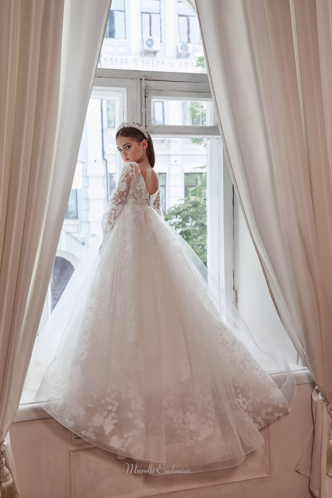 Pentelei 3113 elegance in floral lace: a dress with long lace sleeves and a dramatic train  | Girls Formal Dress