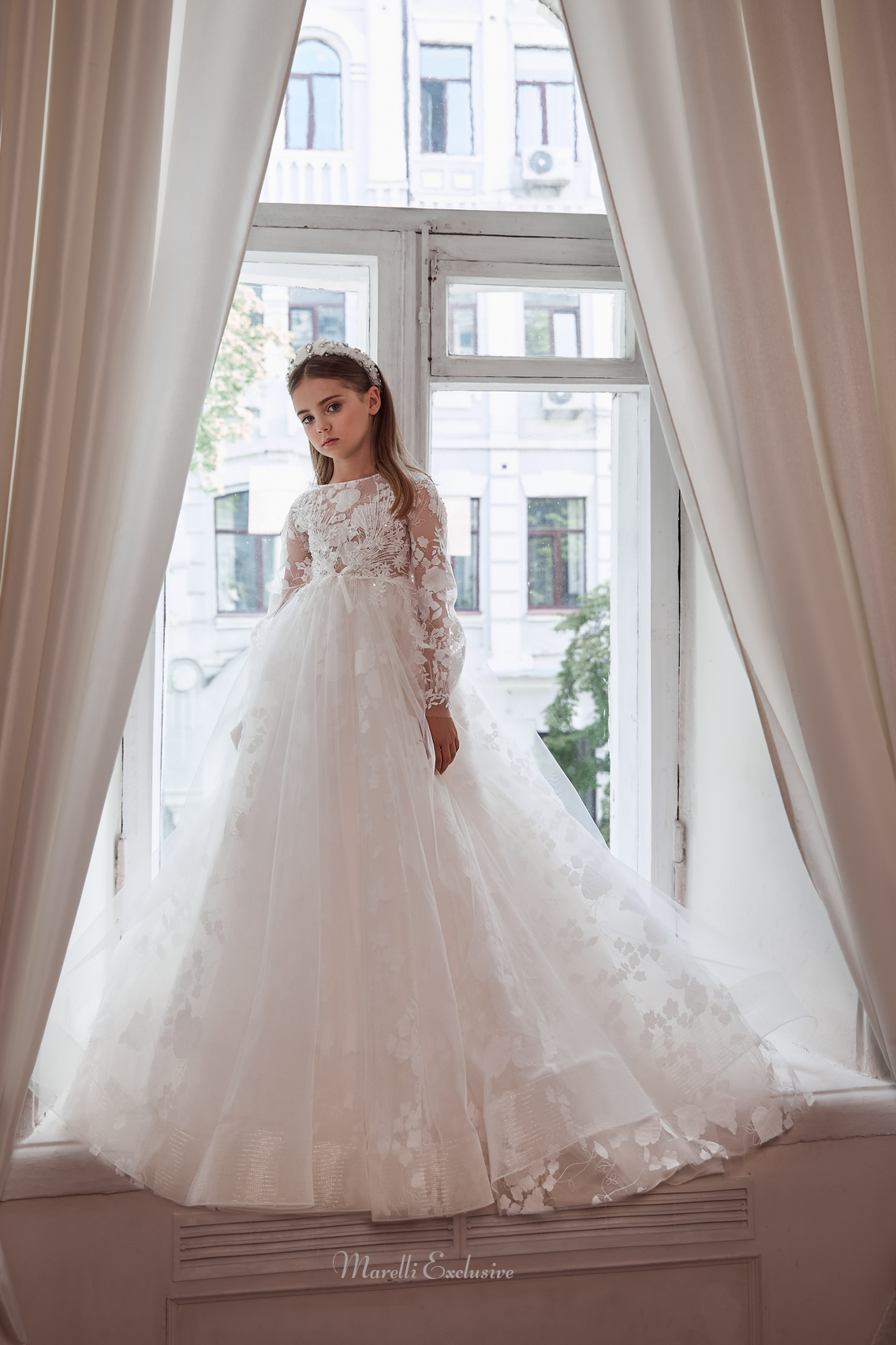Pentelei 3113 elegance in floral lace: a dress with long lace sleeves and a dramatic train  | Girls Formal Dress
